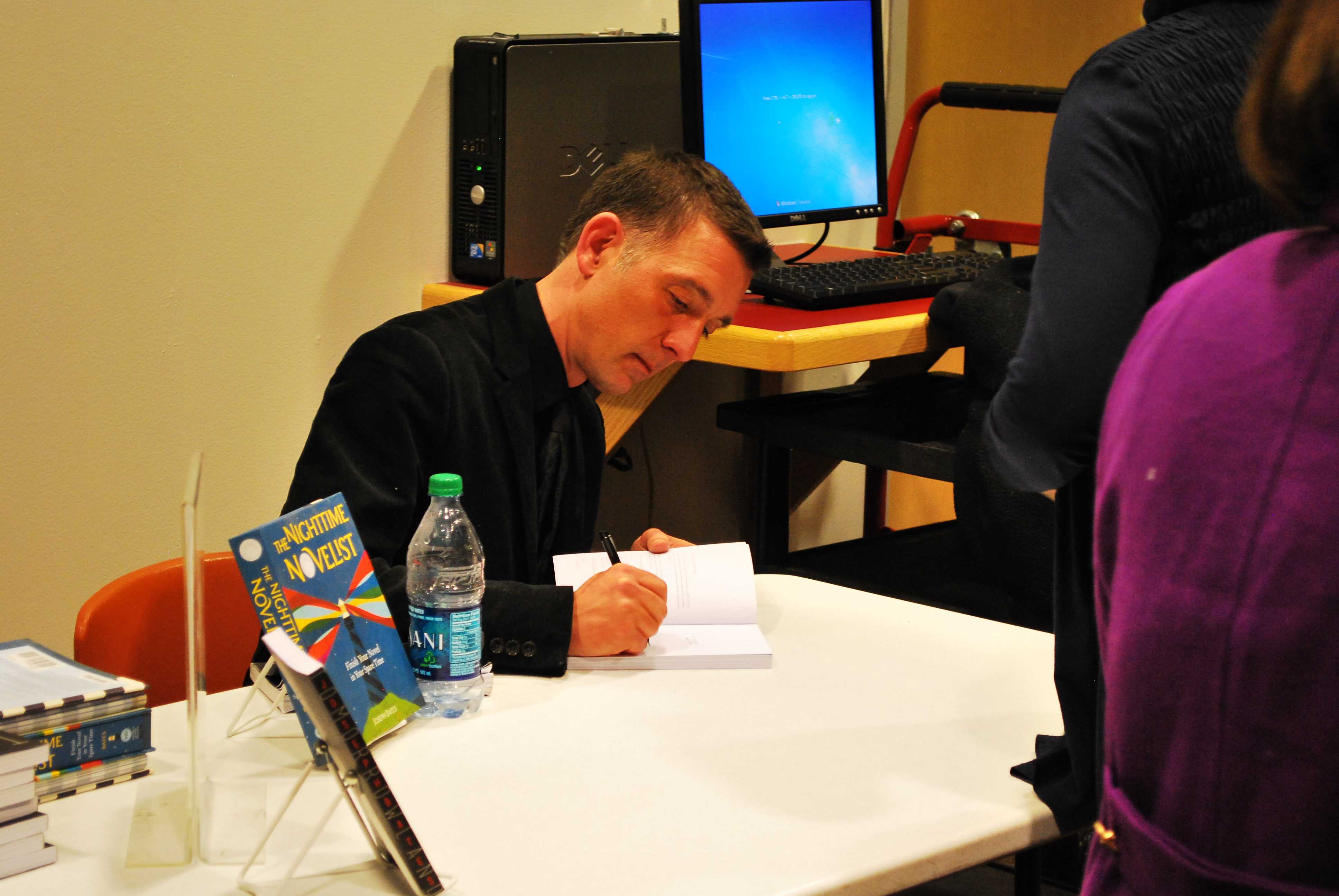Author Joseph Bates signs his book for a student. (Photo/Nick Wort)