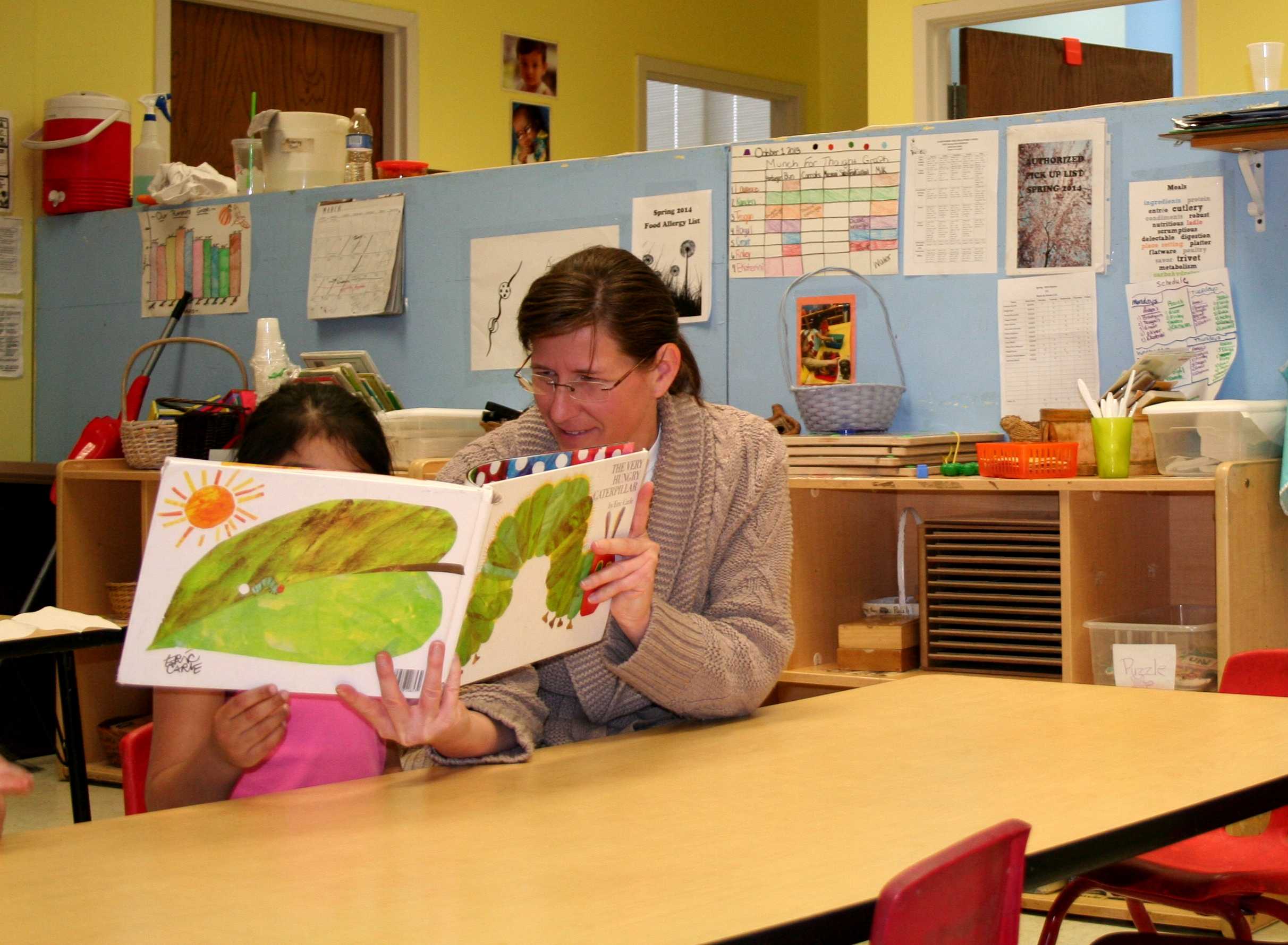 Kim Cooper, Teacher’s Assistant at IU South Bend’s Child Development Center, reading to children after lunchtime. (Preface Photo/Izza Jatala)