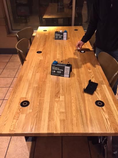 Wireless charging stations are imbedded in the table to allow an aesthetically pleasing way to charge your phone. Photo credit/Powermat