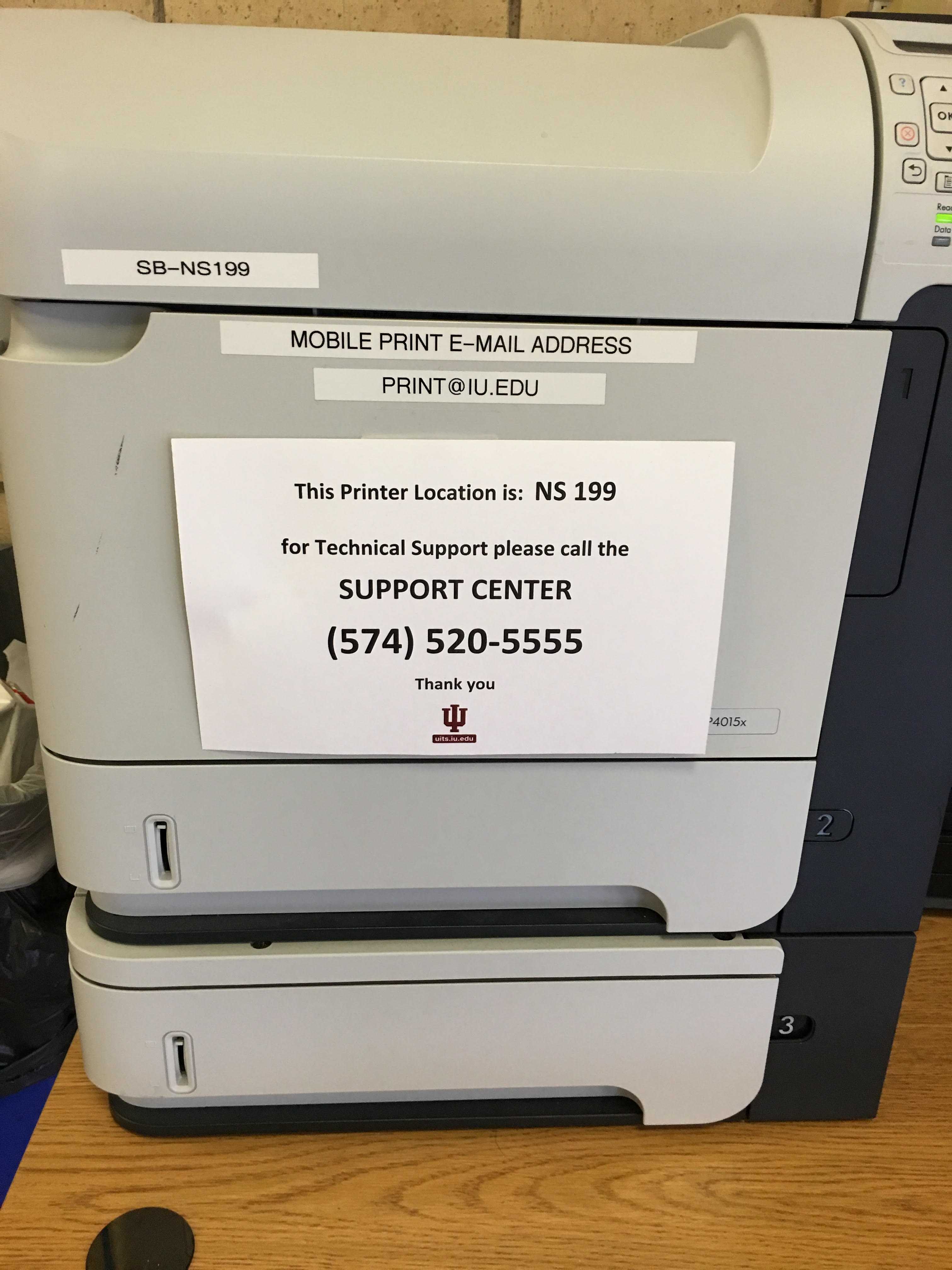 Signs are placed on printers that inform students the printer location and how to contact Tech support for assistance. Photo Credit/Paul Sharpe