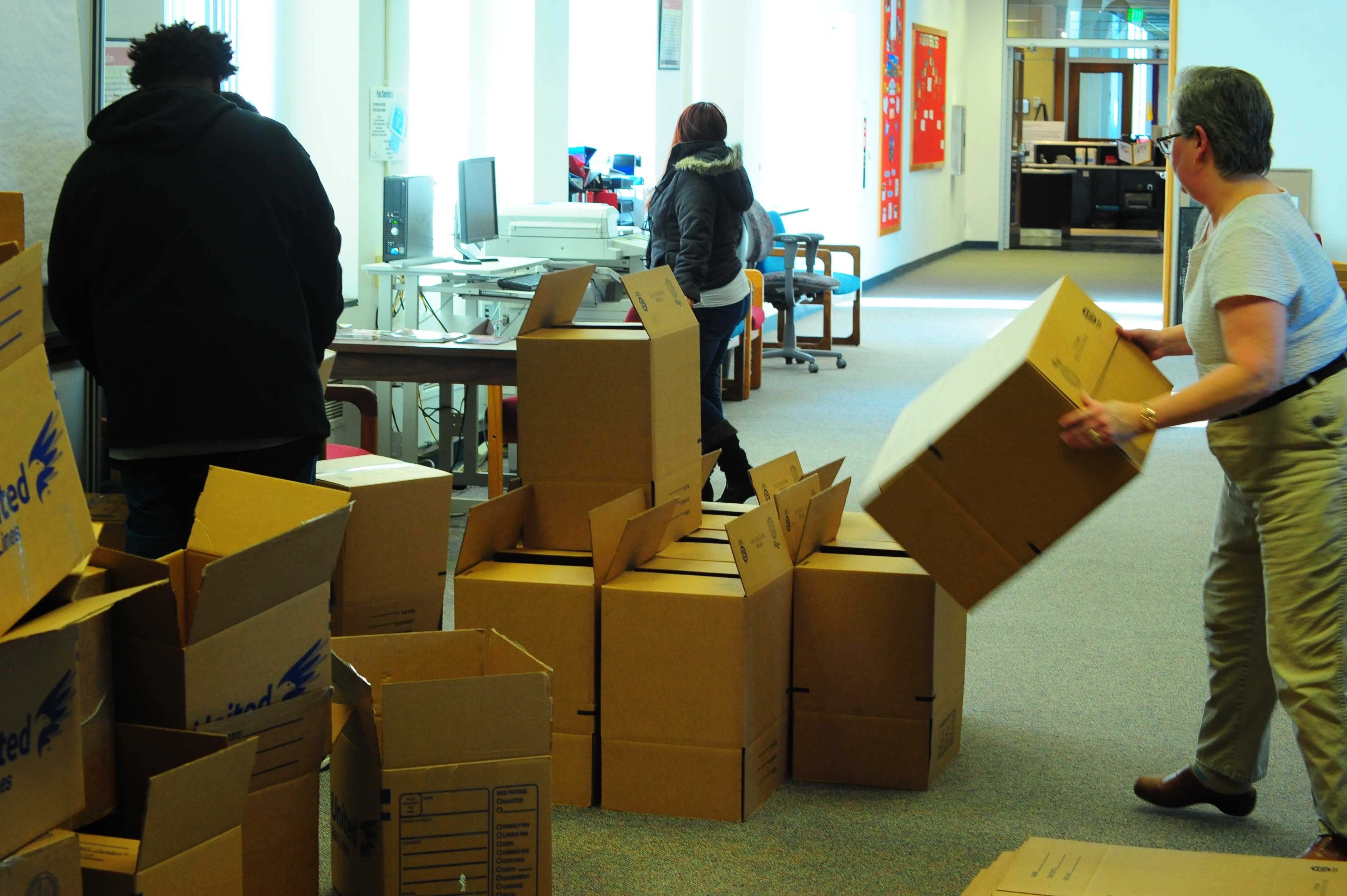 Business as usual continues in the Administration Building as boxes pile up around workers getting ready for a move. Photo Credit/Michael Montana