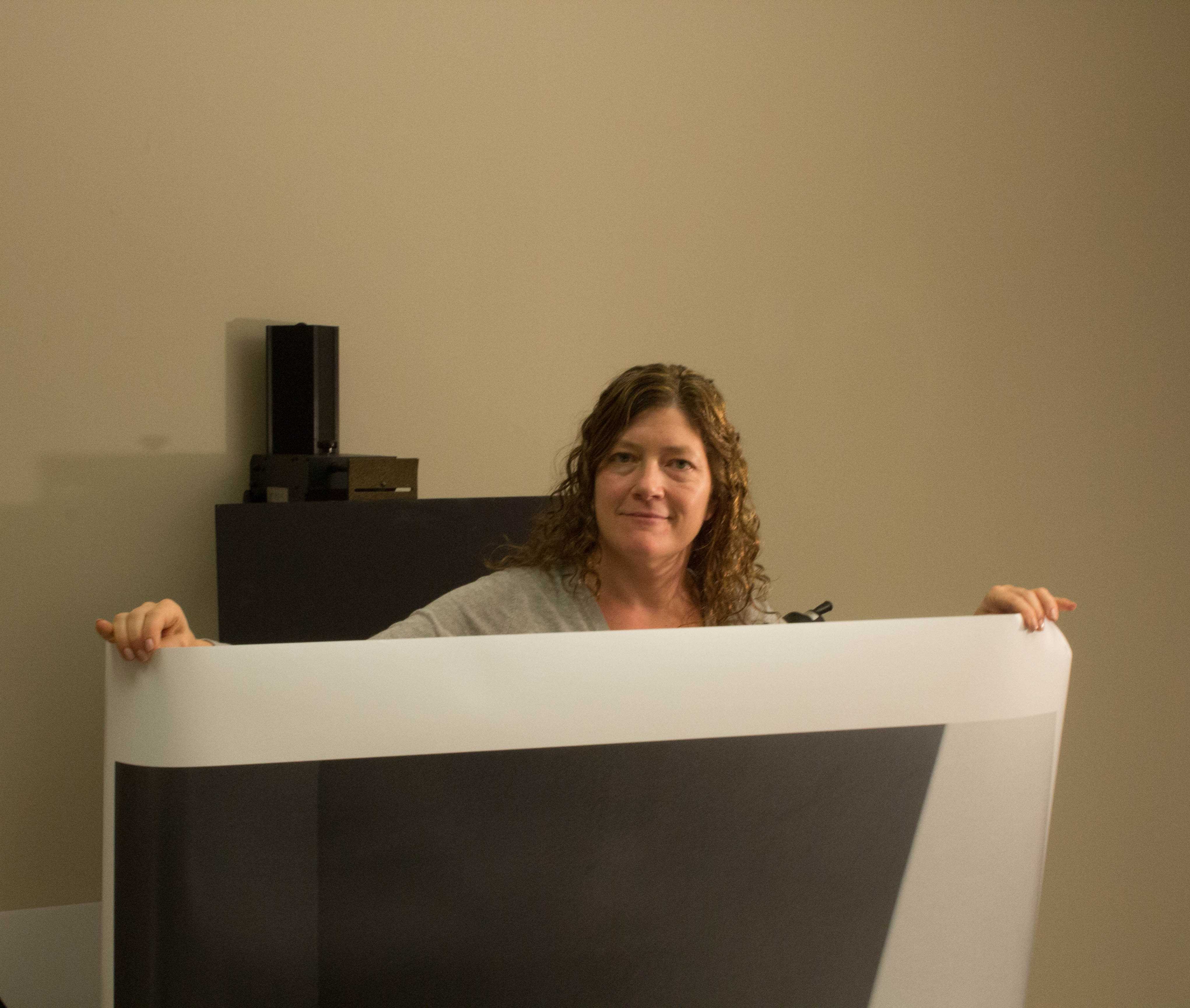 Chair of the Fine Arts Department, Susan Moore, poses with the prints she will exhibit. PHOTO/Ian Brown