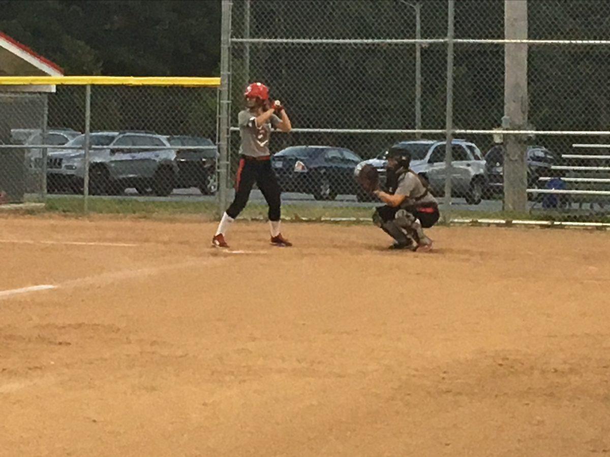 Junior outfielder Kat Bessler waits for the pitch to be delivered at the Softball practice last Tuesday night, as Freshman catcher Emily Anglin looks on.  PHOTO CREDIT/Henry Freese.

