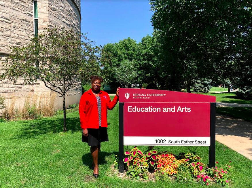 Dr. Michelle Rosemund stands next to Education and Arts building sign. Photo Credit: Anthony Ayala