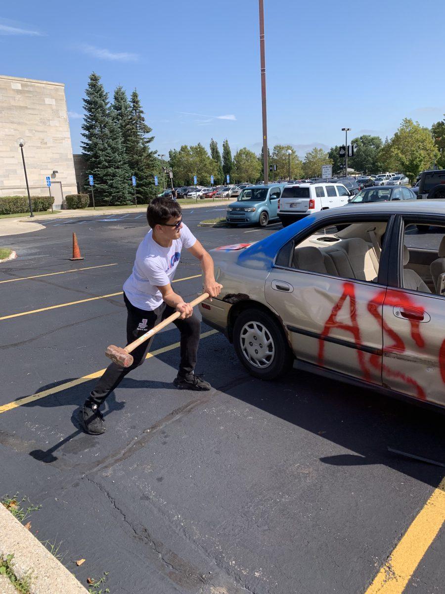 Andrew O’Brien take swings at the scrap car during the event. Photos by/MABEL MYERS