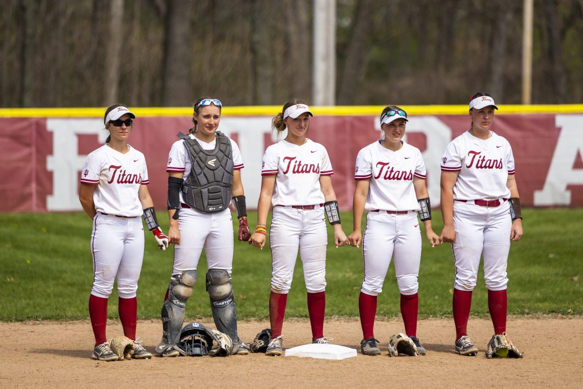 Players hold hands before the IUSB vs. Olivet Nazarene softball game Friday, April 14, 2023 at Dick Pfeil Field in South Bend. (Photo by Michael Caterina/Indiana University South Bend)
