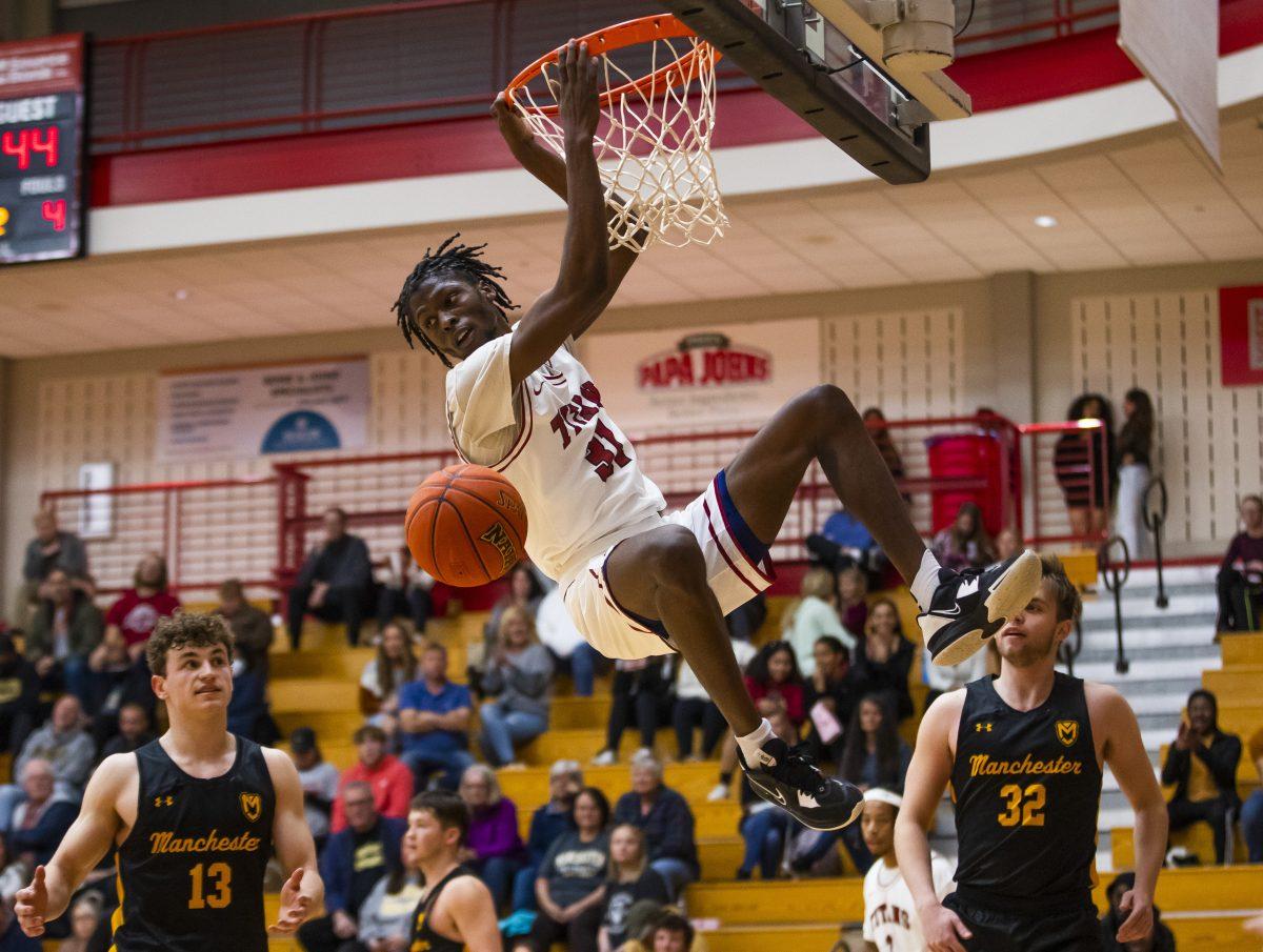 IUSB's Dejon Barney (31) holds on after a dunk during the IUSB vs. Manchester men’s basketball game Thursday, Oct. 27, 2022 at the Student Activities Center on campus at IUSB. (Photo by Michael Caterina/Indiana University South Bend)