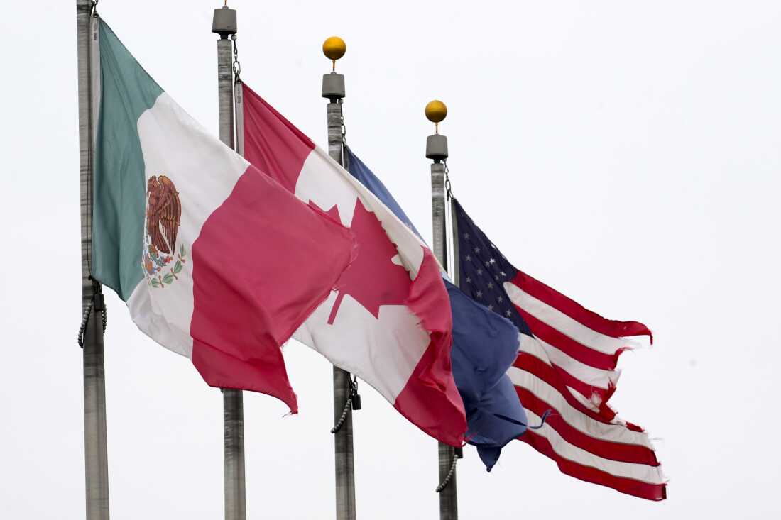 The flags of Mexico, Canada and the United States are shown near the Ambassador Bridge, Monday, Feb. 3, 2025, in Detroit. (AP Photo/Paul Sancya)